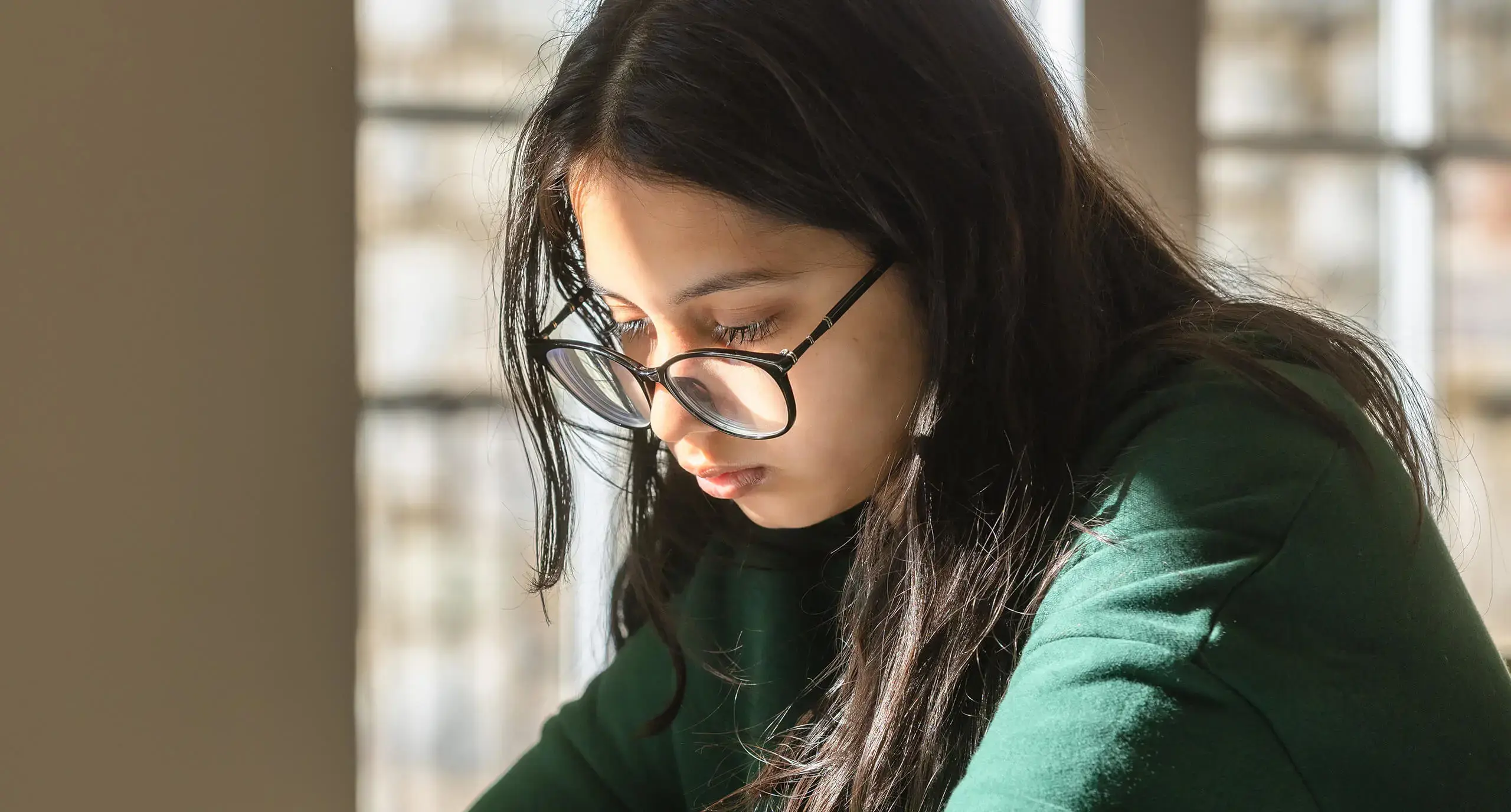 girl wearing glasses and reading