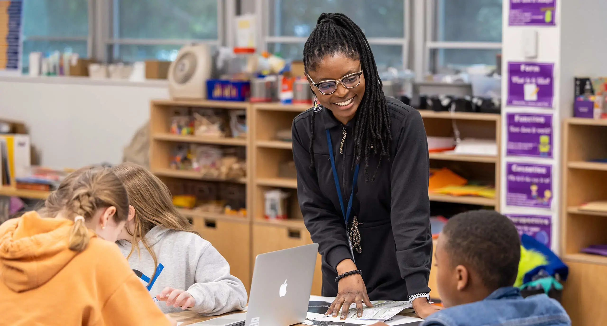 teacher smiling while talking to students