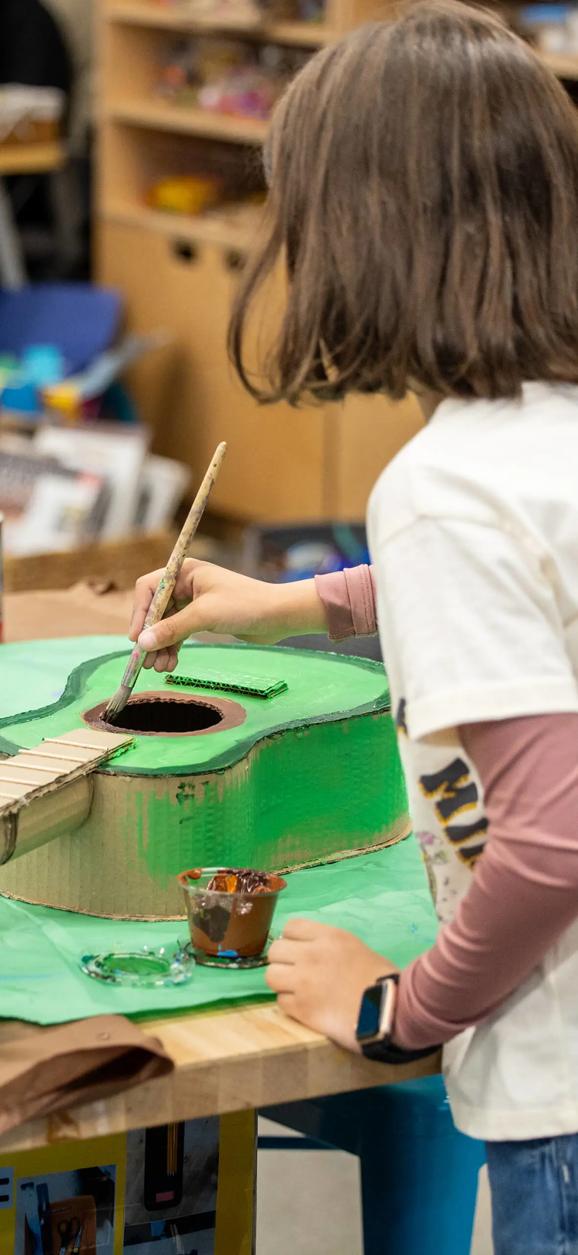 Student painting a guitar green