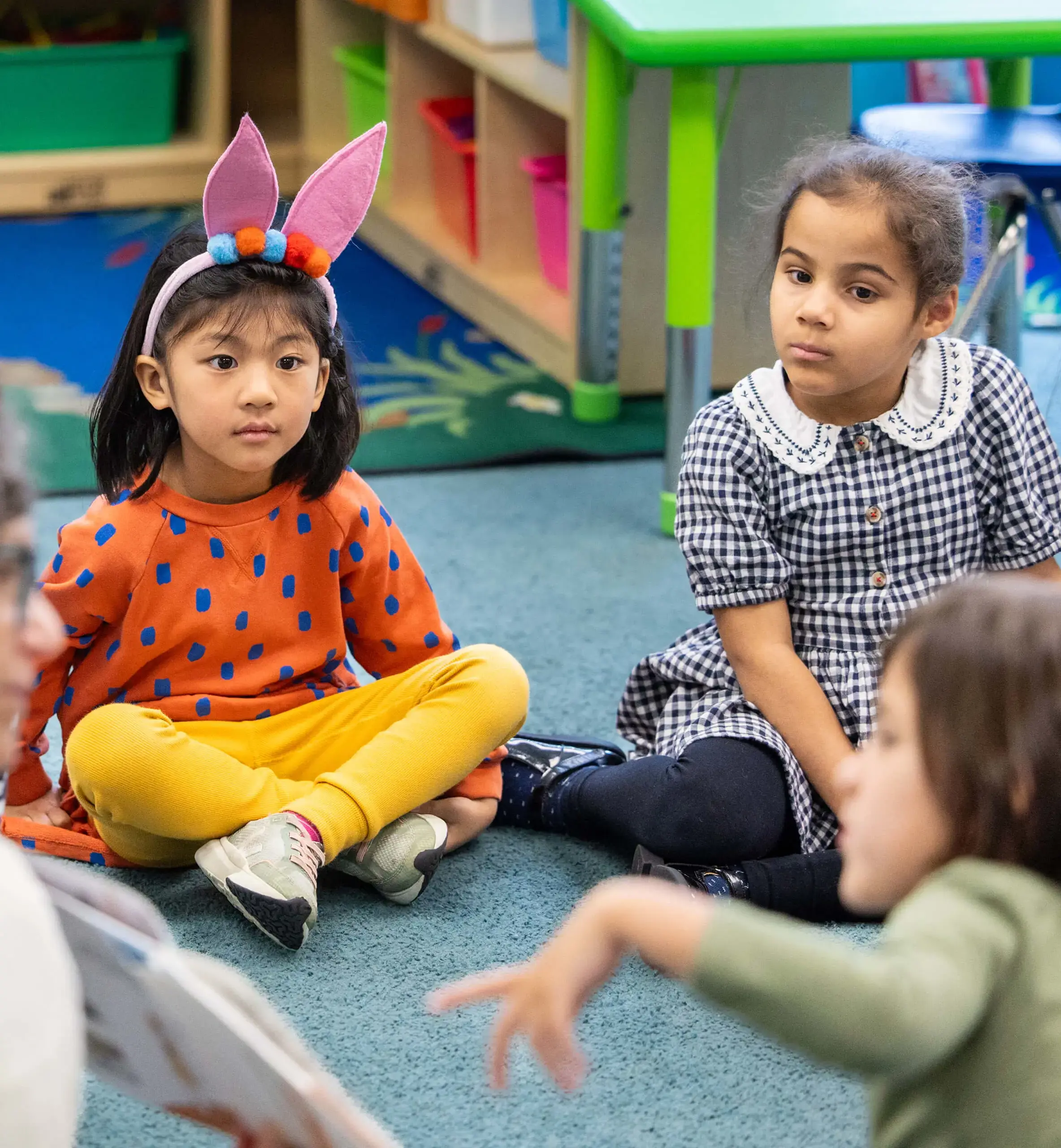 little kids in class, one with rabbit ears