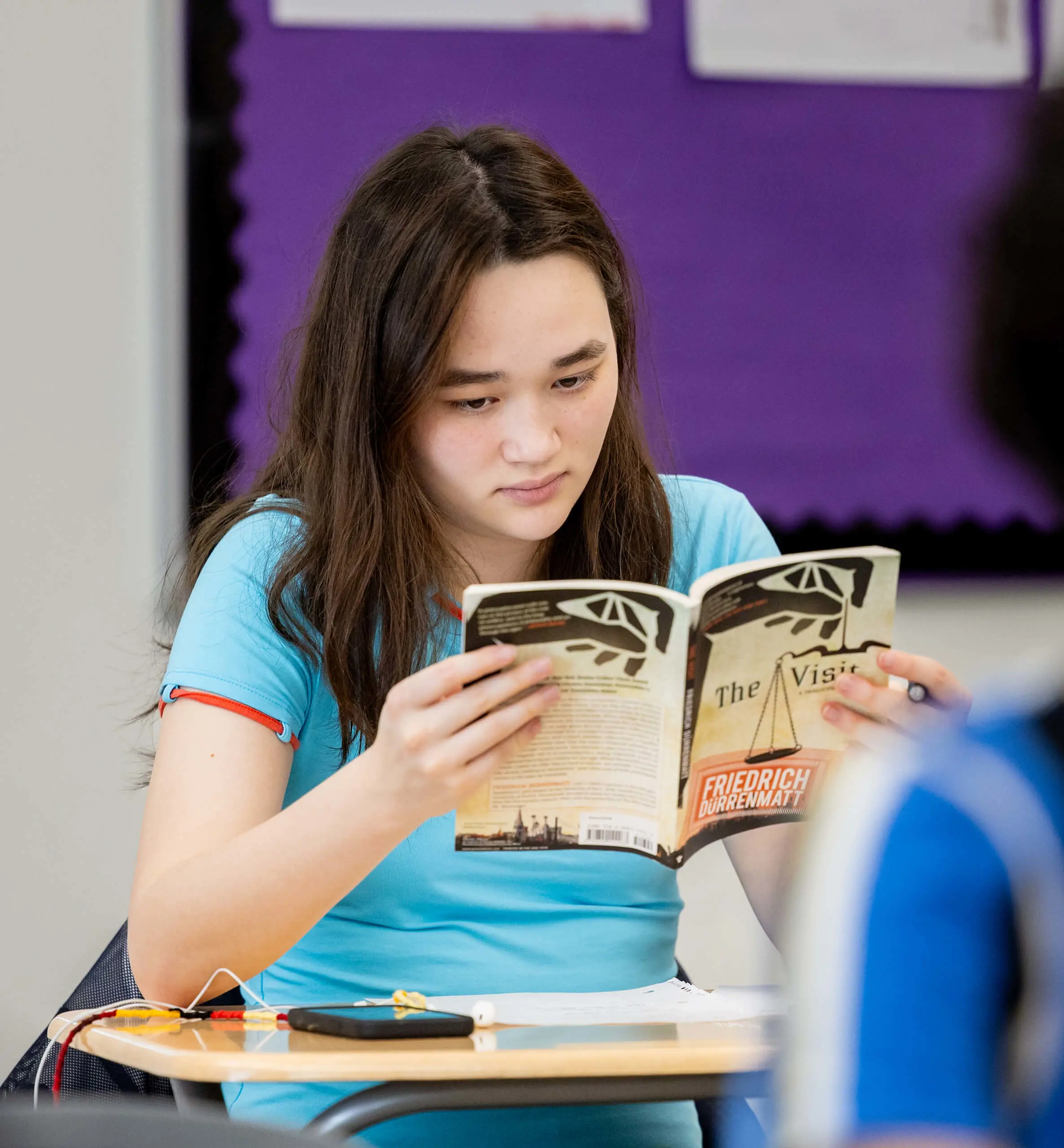 Student reading in a classroom