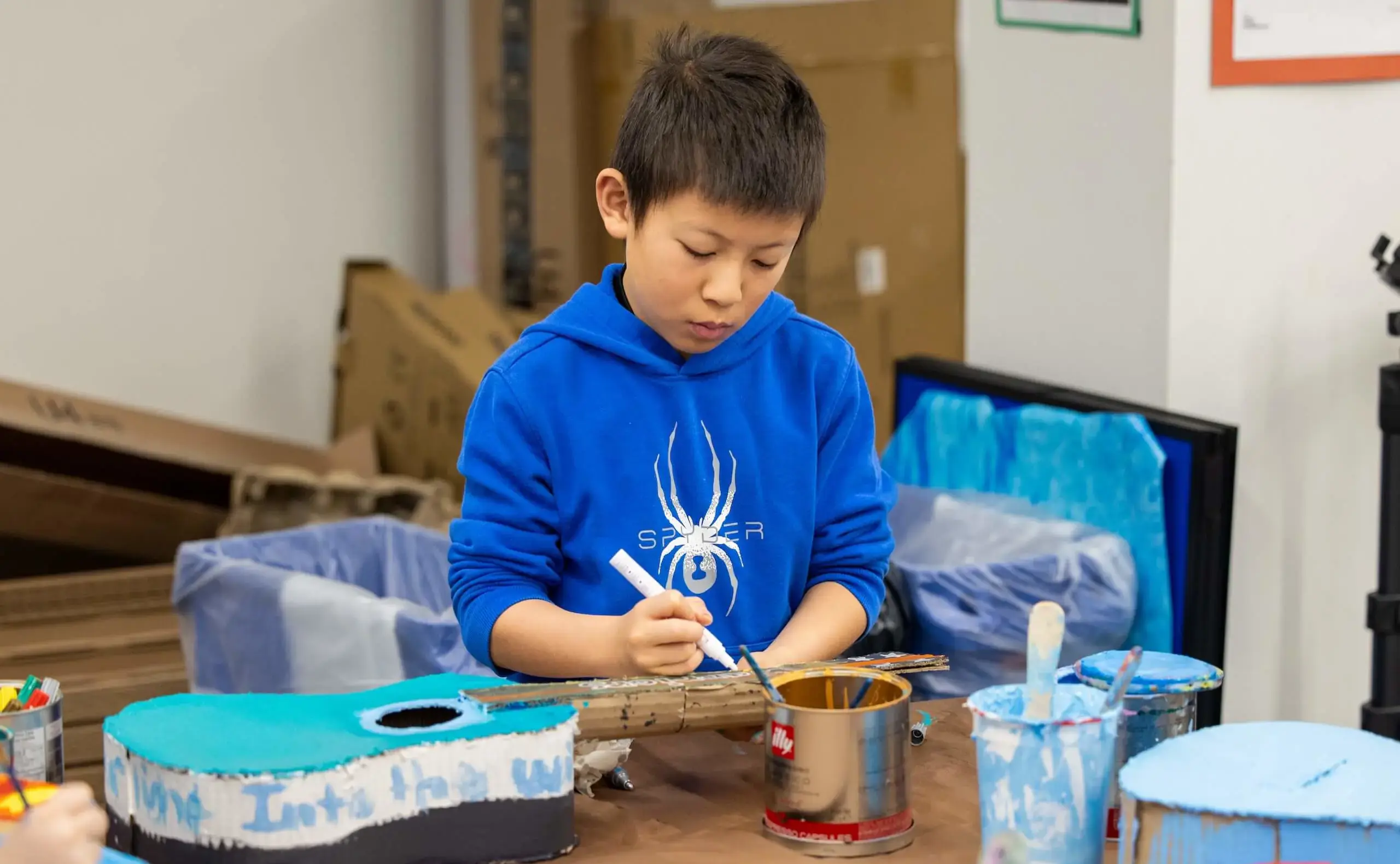 Student painting guitar blue