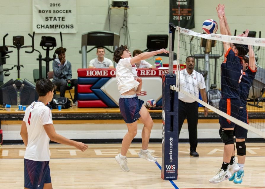 Boys playing indoor volleyball