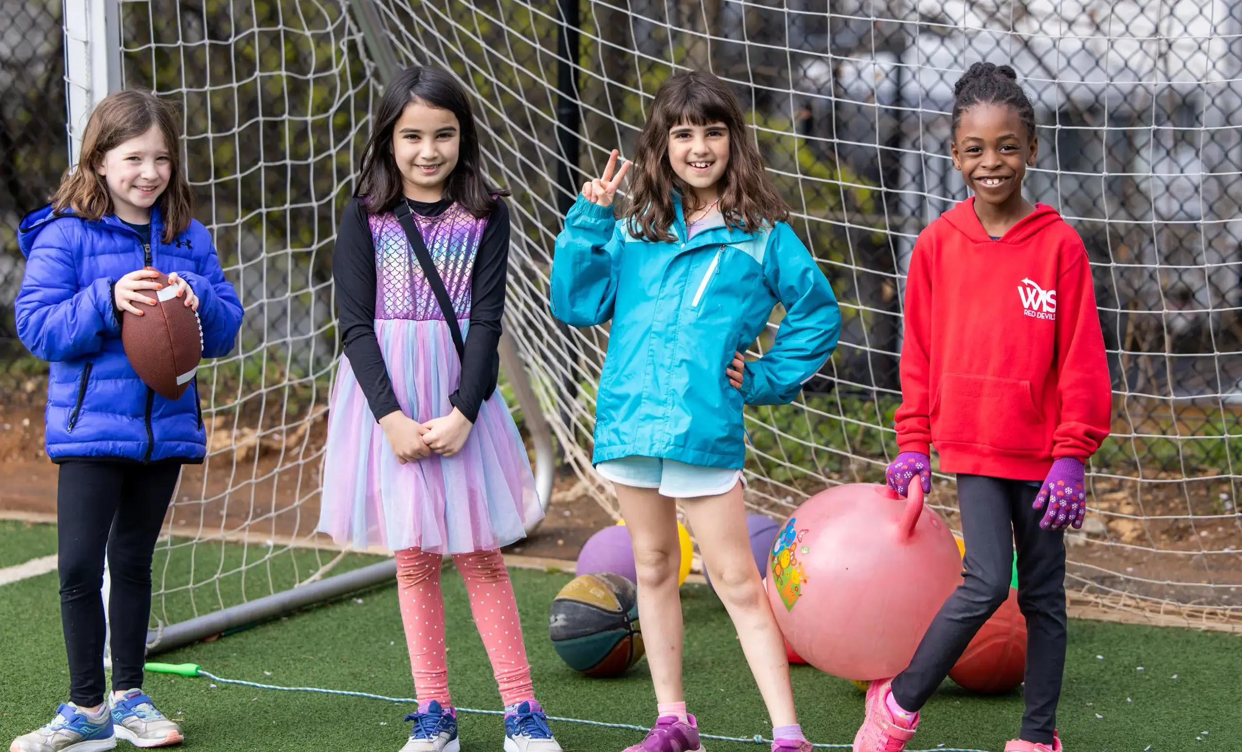 Four girls standing in a soccer goal