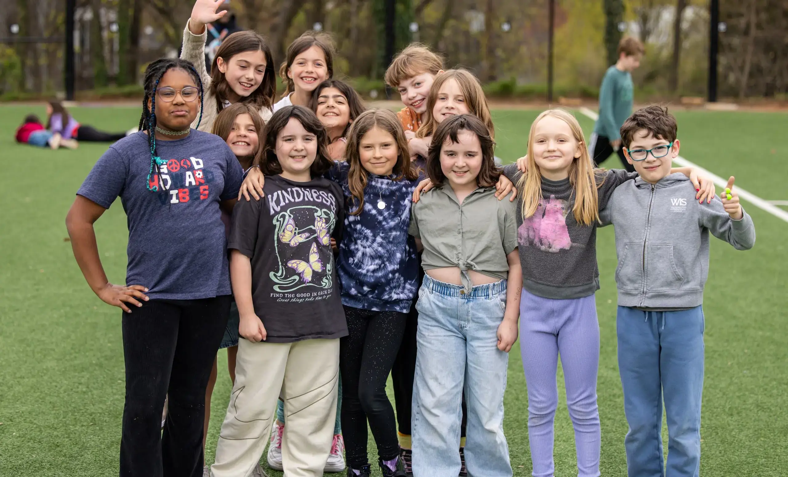 Children on a pitch arm in arm