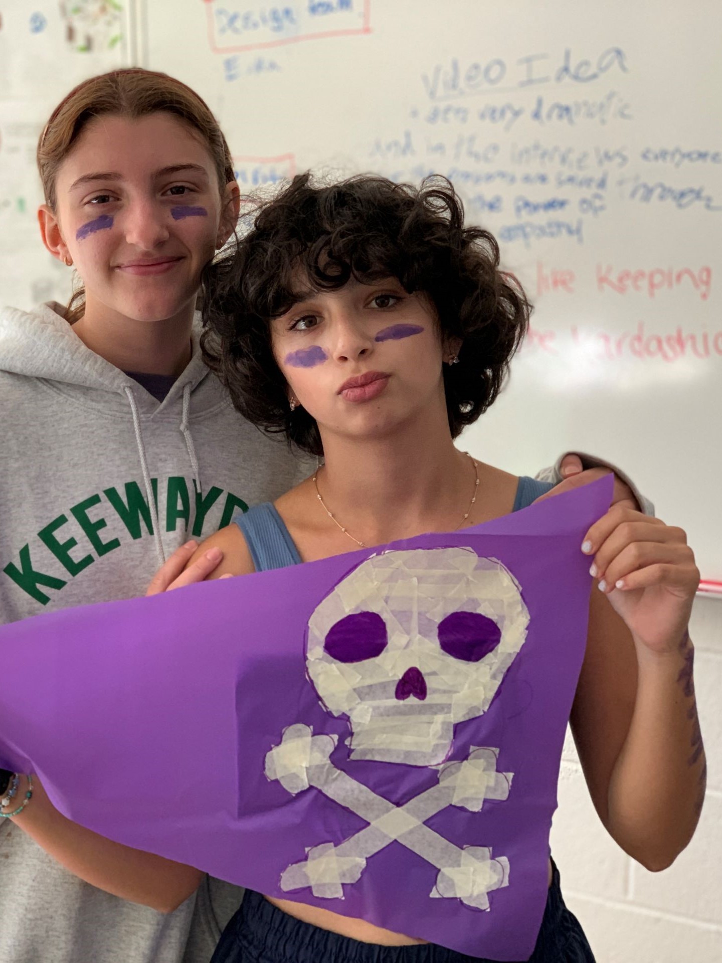 Two students holding up a skull and crossbones flag