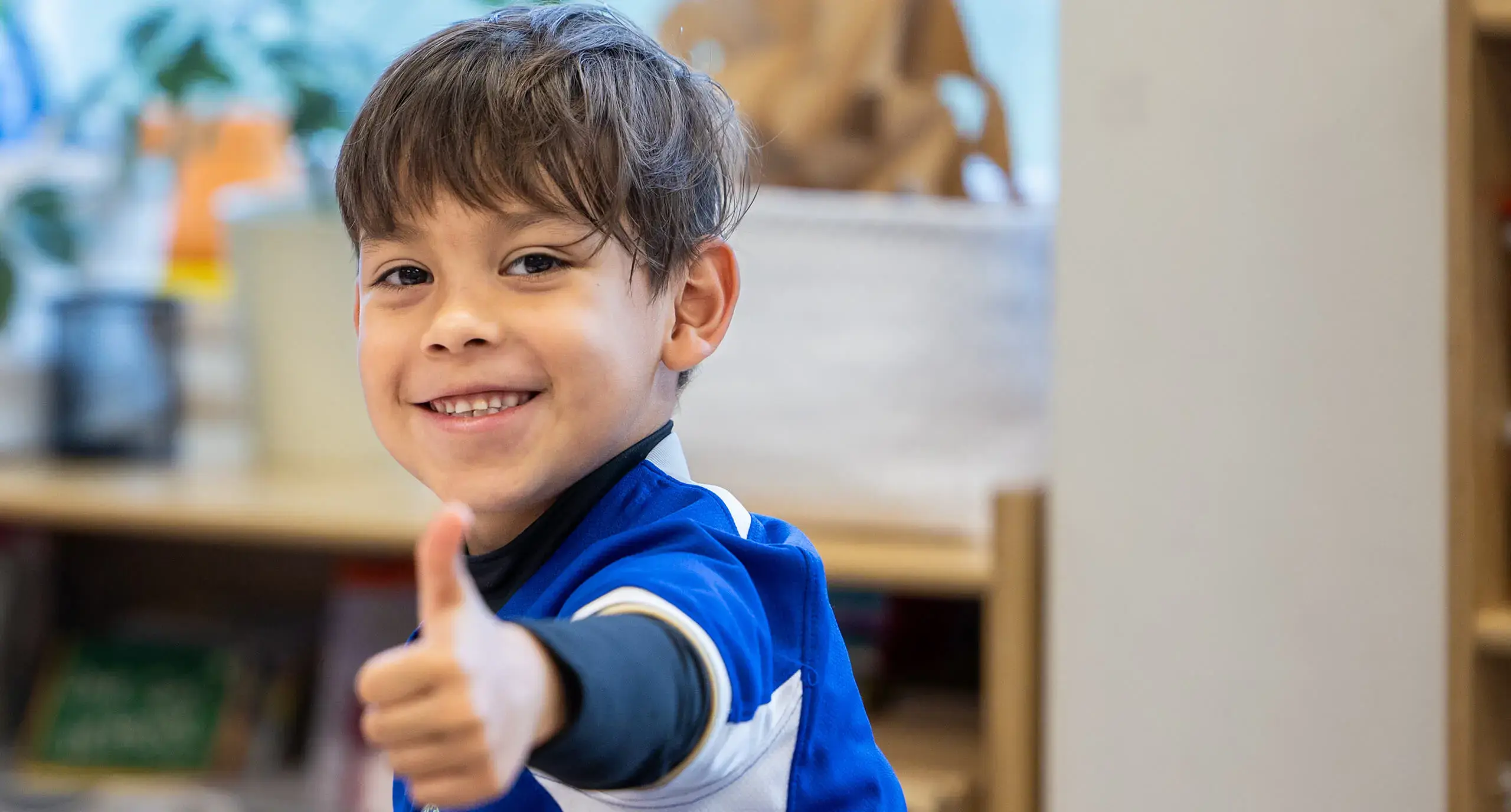 young boy giving a thumbs up