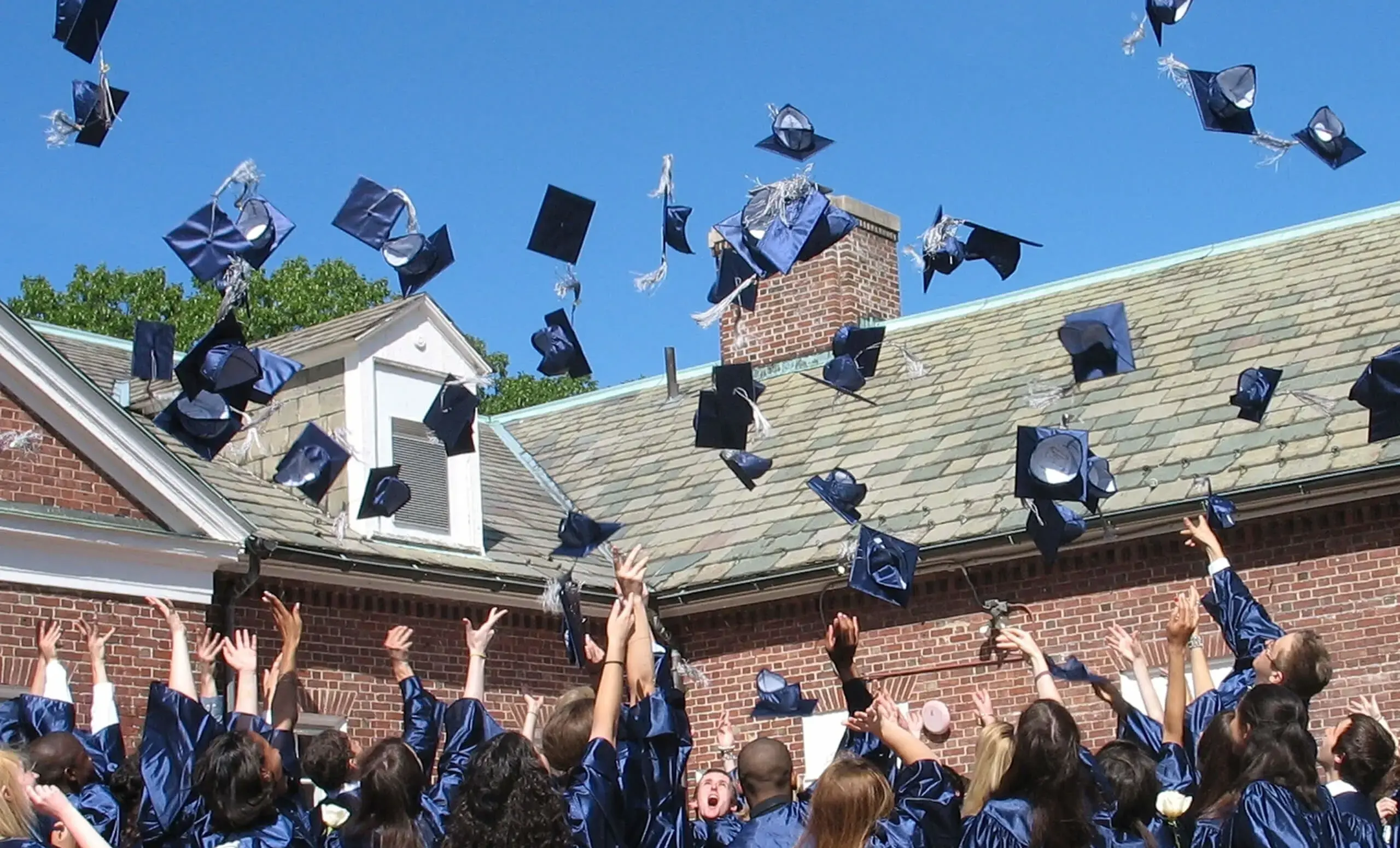 Students tossing graduation caps