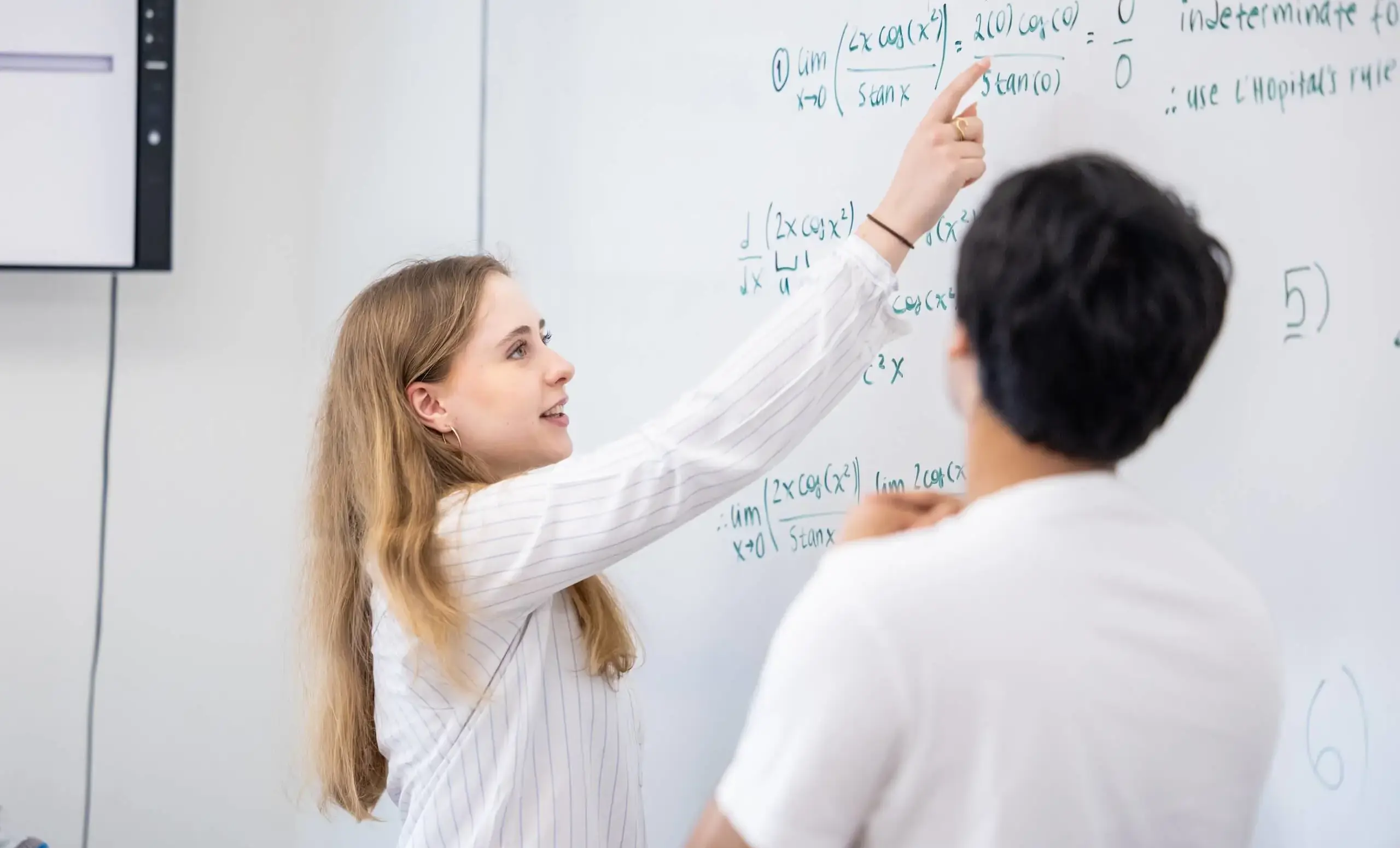 Students doing math on a whiteboard